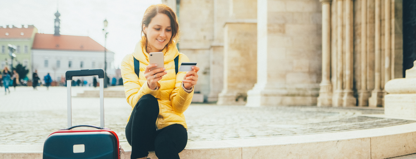 Woman traveling using phone and looking at a travel card
