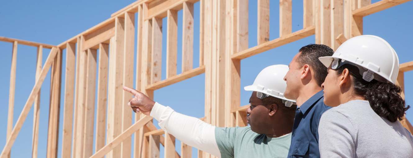 Construction worker pointing at a house being built 